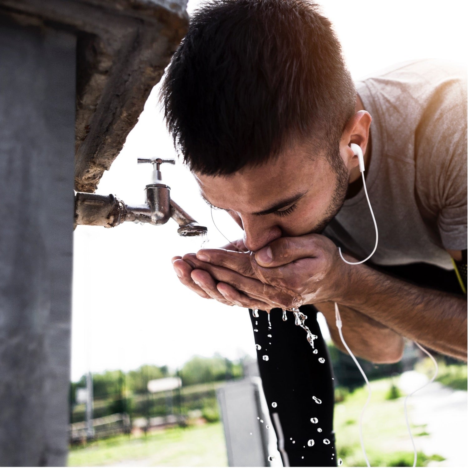 Sportler trinkt Wasser aus der Leitung