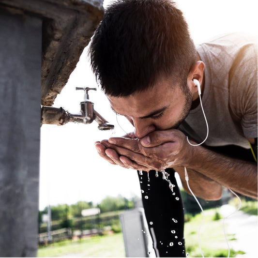 Sportler trinkt Wasser aus der Leitung