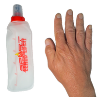 SportBrennstoff BEGLEITER - Trinkflasche neben einer Hand im Größenvergleich. Flexible, tropfsichere Flasche für Outdoor-Aktivitäten.