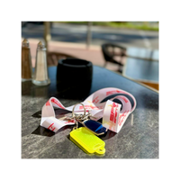 SportBrennstoff Schlüsselband / Lanyard für einen besonderen Auftritt mit Logo in Weiß-Rot, auf einem Tisch mit Schlüsseln und Anhängern platziert.